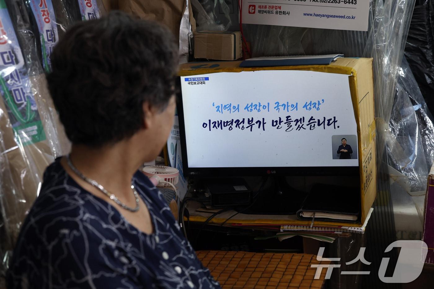 한 전통시장의 상인이 국정기획위원회 국민보고대회 '국민이 주인인 나라 함께 행복한 대한민국’ 생중계를 지켜보는 모습. (뉴스1DB)/뉴스1