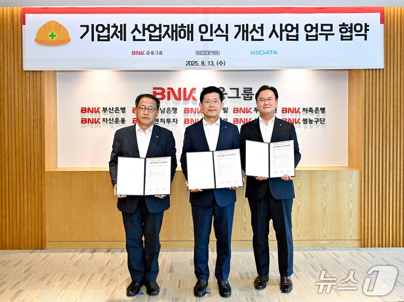 본문 이미지 - 13일 BNK금융그룹에서 열린 기업체 산업재해 인식 개선 사업 업무 협약식에서 홍두선 한국평가데이터 대표(왼쪽부터), 빈대인 BNK금융그룹 회장, 김종윤 NICE평가정보 대표가 협약서를 들어 보이고 있다. (BNK금융그룹 제공. 재판매 및 DB 금지)