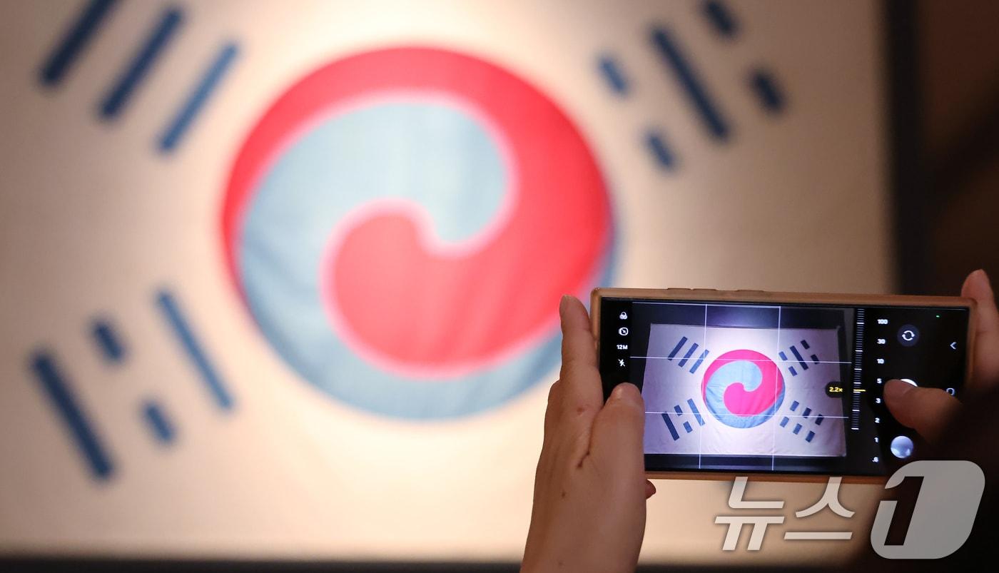 광복절을 하루 앞둔 14일 오후 서울 용산구 국립중앙박물관을 찾은 관광객들이 우리나라에 남아있는 가장 오래된 태극기를 관람하고 있다. 2025.8.14/뉴스1 ⓒ News1 장수영 기자