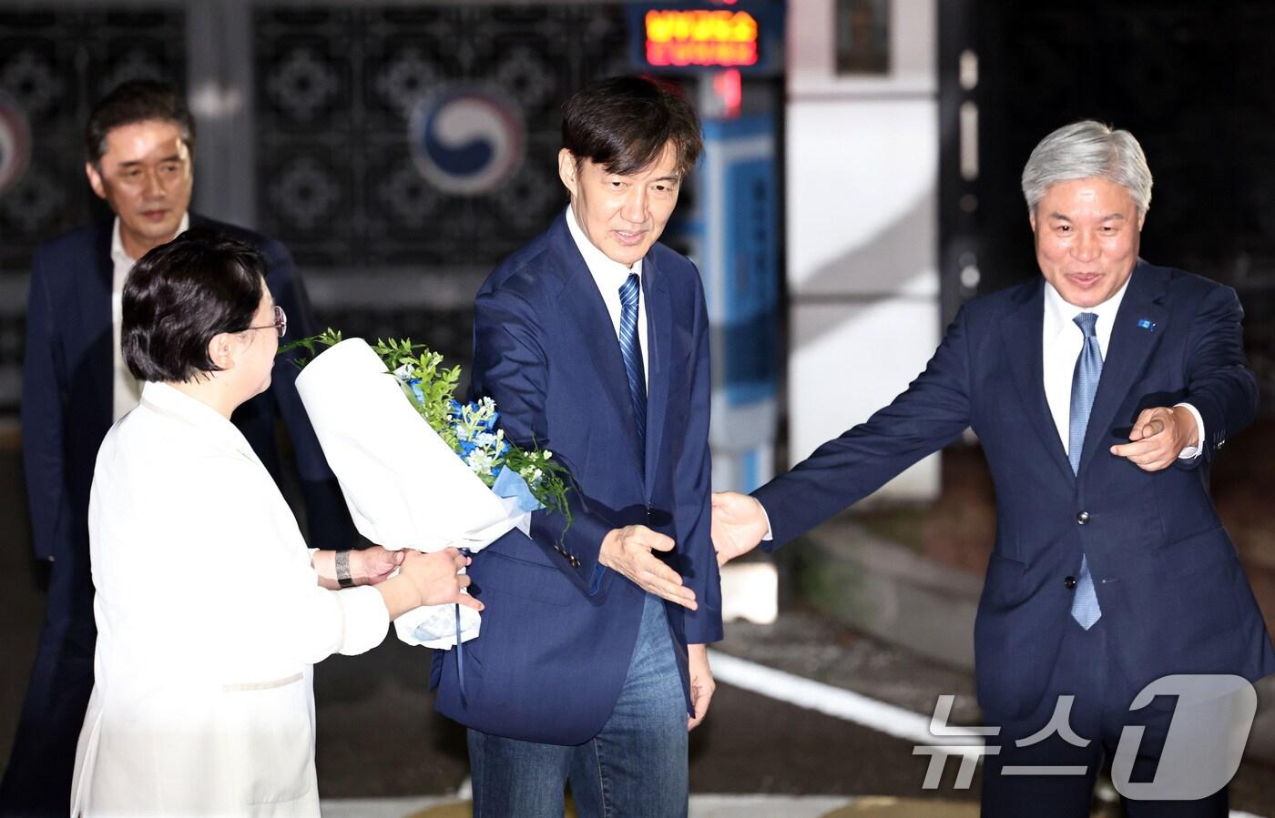 이재명 정부 첫 특별사면·복권 대상에 오른 조국 전 조국혁신당 대표가 15일 새벽 구로구 서울남부구치소를 나서며 김선민 대표 권한대행에게 꽃다발을 받고 있다. 2025.8.15/뉴스1 ⓒ News1 구윤성 기자