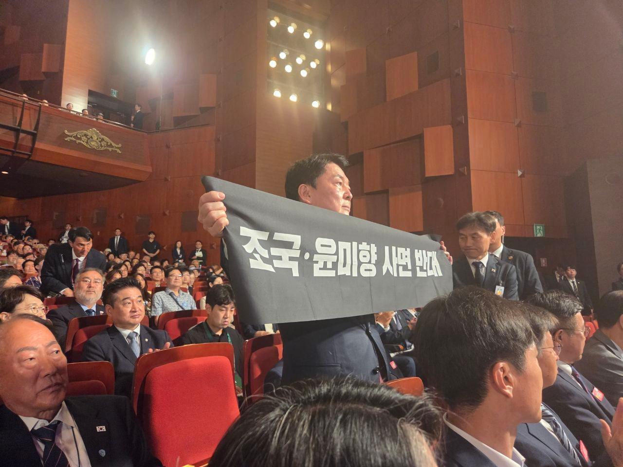 본문 이미지 - 안철수 국민의힘 당대표 후보가 15일 제80주년 광복절 경축식에 참석해 축사 중인 이재명 대통령을 향해 항의 메시지를 전달하는 모습 (안철수 캠프 제공)