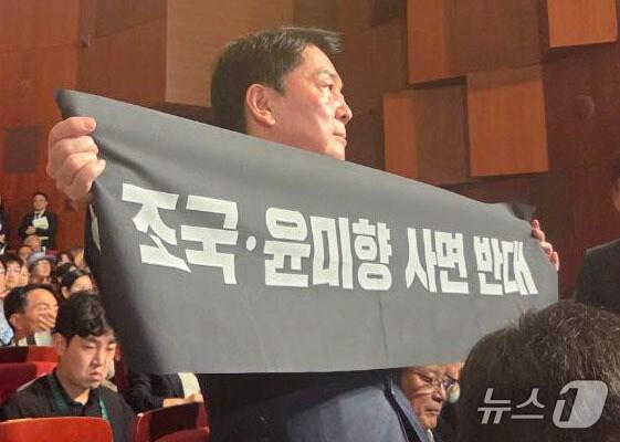 본문 이미지 - 안철수 국민의힘 당대표 후보가 15일 오전 서울 종로구 세종문화회관에서 열린 제80주년 광복절 경축식에 참석해 경축사 중인 이재명 대통령을 향해 조국 전 조국혁신당 대표와 윤미향 전 의원의 사면 반대 플래카드를 들어보이며 항의하고 있다. &#40;안철수 캠프 제공&#41; 2025.8.15/뉴스1