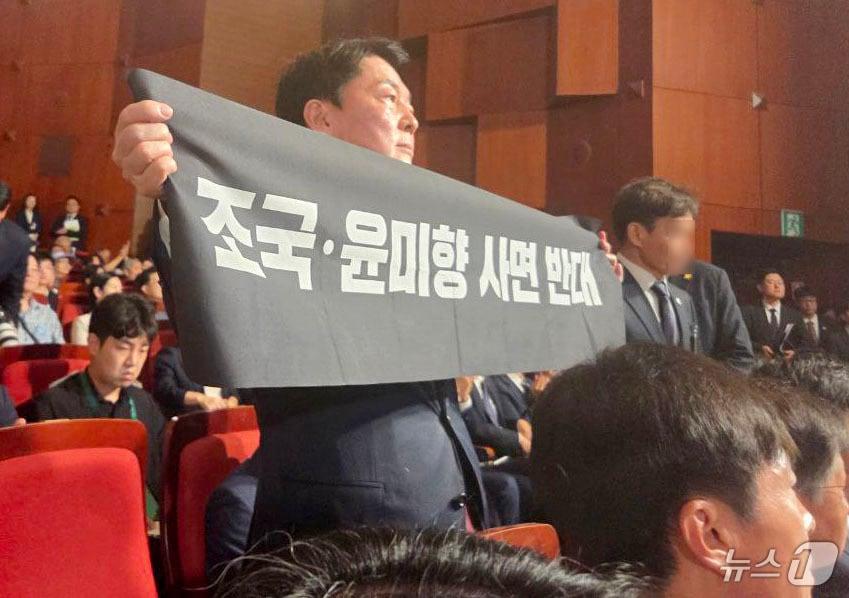 본문 이미지 - 안철수 국민의힘 당대표 후보가 15일 오전 서울 종로구 세종문화회관에서 열린 제80주년 광복절 경축식에 참석해 경축사 중인 이재명 대통령을 향해 조국 전 조국혁신당 대표와 윤미향 전 의원의 사면 반대 플래카드를 들어보이며 항의하고 있다. &#40;안철수 캠프 제공&#41; 2025.8.15/뉴스1