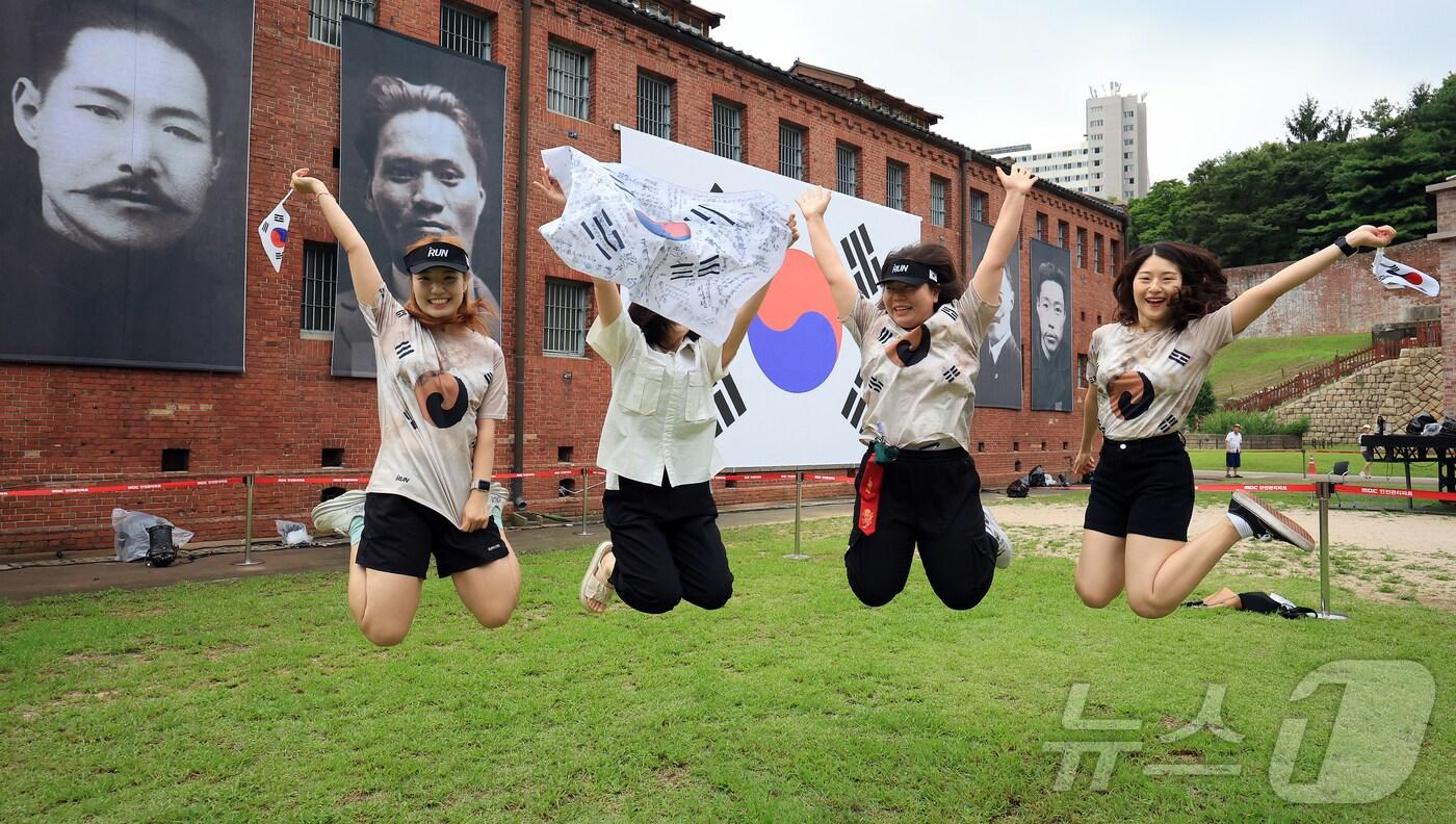 제80주년 광복절인 15일 서울 서대문형무소역사관을 찾은 시민들이 대형 태극기와 독립운동가들의 얼굴이 담긴 현수막 앞에서 &#39;대한독립만세&#39;를 외치고 있다. 2025.8.15/뉴스1 ⓒ News1 김진환 기자