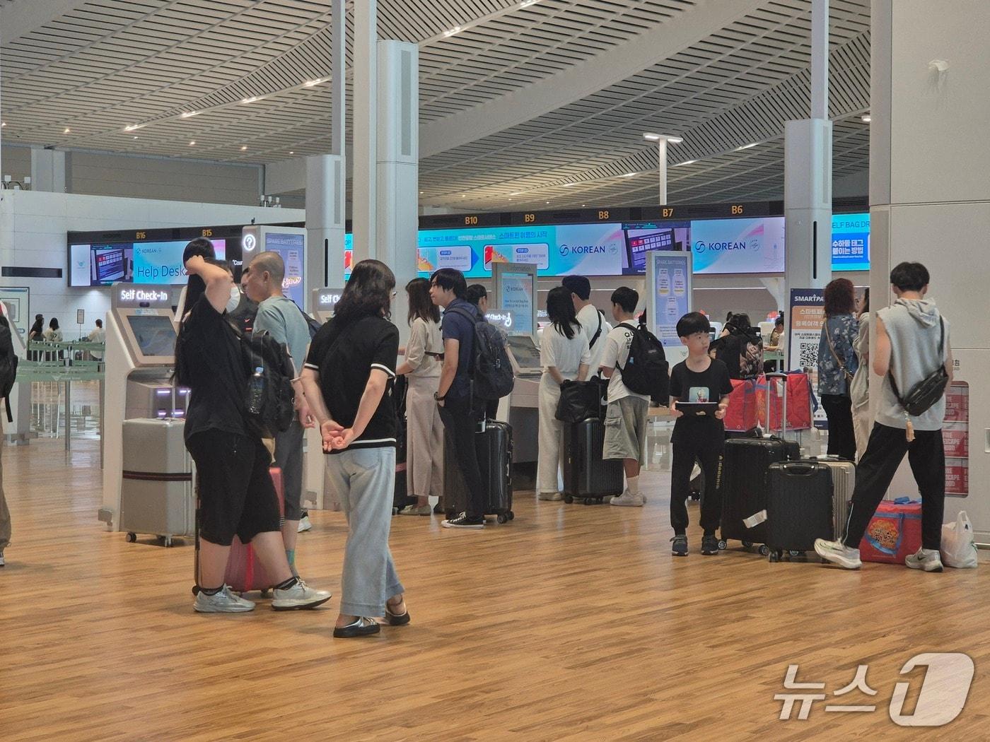 본문 이미지 - 광복절인 15일 인천국제공항 제2여객터미널 이용객들이 셀프 체크인을 하고 있다.이시명기자/뉴스1