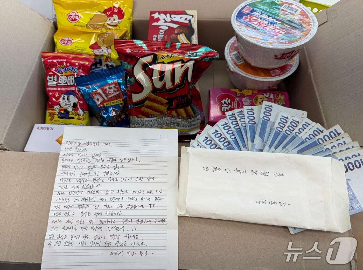 본문 이미지 - 지난 13일 부산 북구 덕천지구대에 자신을 세 아이 아빠라고 밝힌 남성이 놓고 간 간식꾸러미와 현금.(부산 북구 제공. 재판매 및 DB금지)