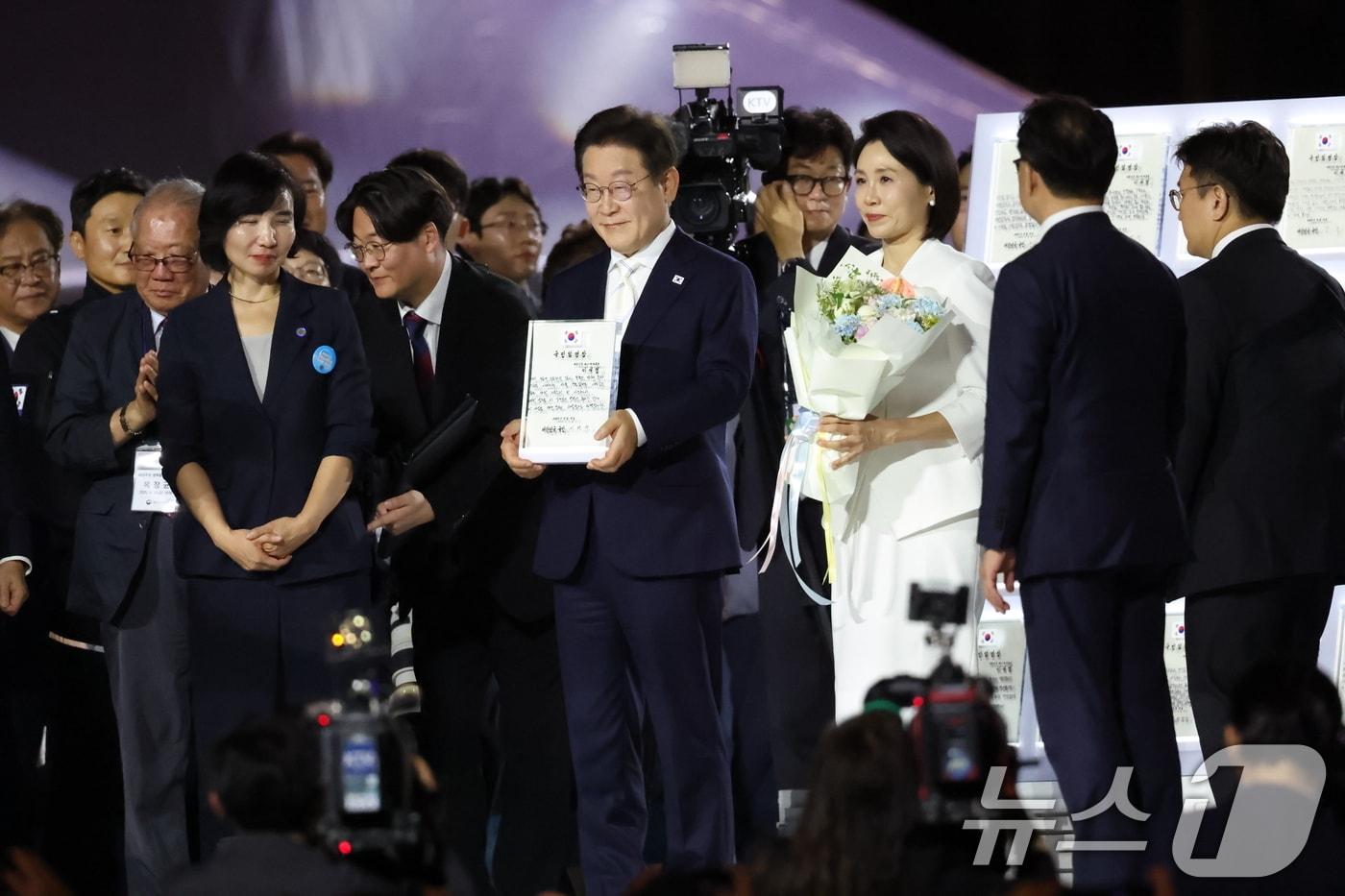 이재명 대통령이 15일 오후 서울 종로구 광화문광장에서 열린 &#39;광복 80년, 국민 주권으로 미래를 세우다&#39; 제21대 대통령 국민 임명식에서 국민 대표 80인이 참여한 임명장을 전달 받고 있다. 2025.8.15/뉴스1 ⓒ News1 김명섭 기자