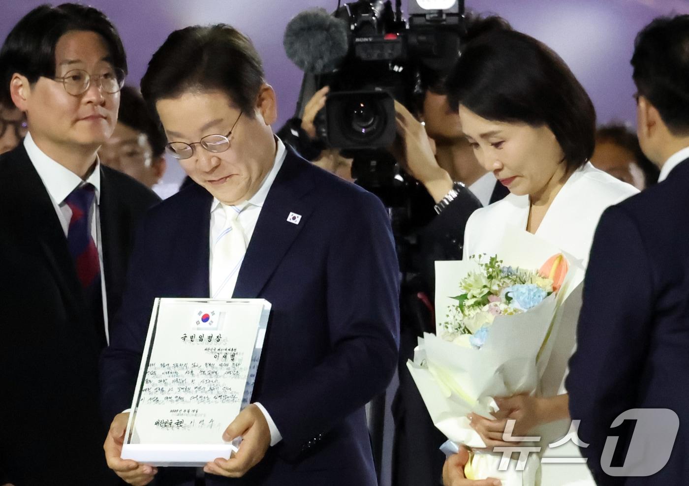 이재명 대통령이 15일 오후 서울 종로구 광화문광장에서 열린 '광복 80년, 국민 주권으로 미래를 세우다' 제21대 대통령 국민 임명식에서 국민 대표 80인이 참여한 임명장을 전달 받고 있다. 2025.8.15/뉴스1 ⓒ News1 김명섭 기자