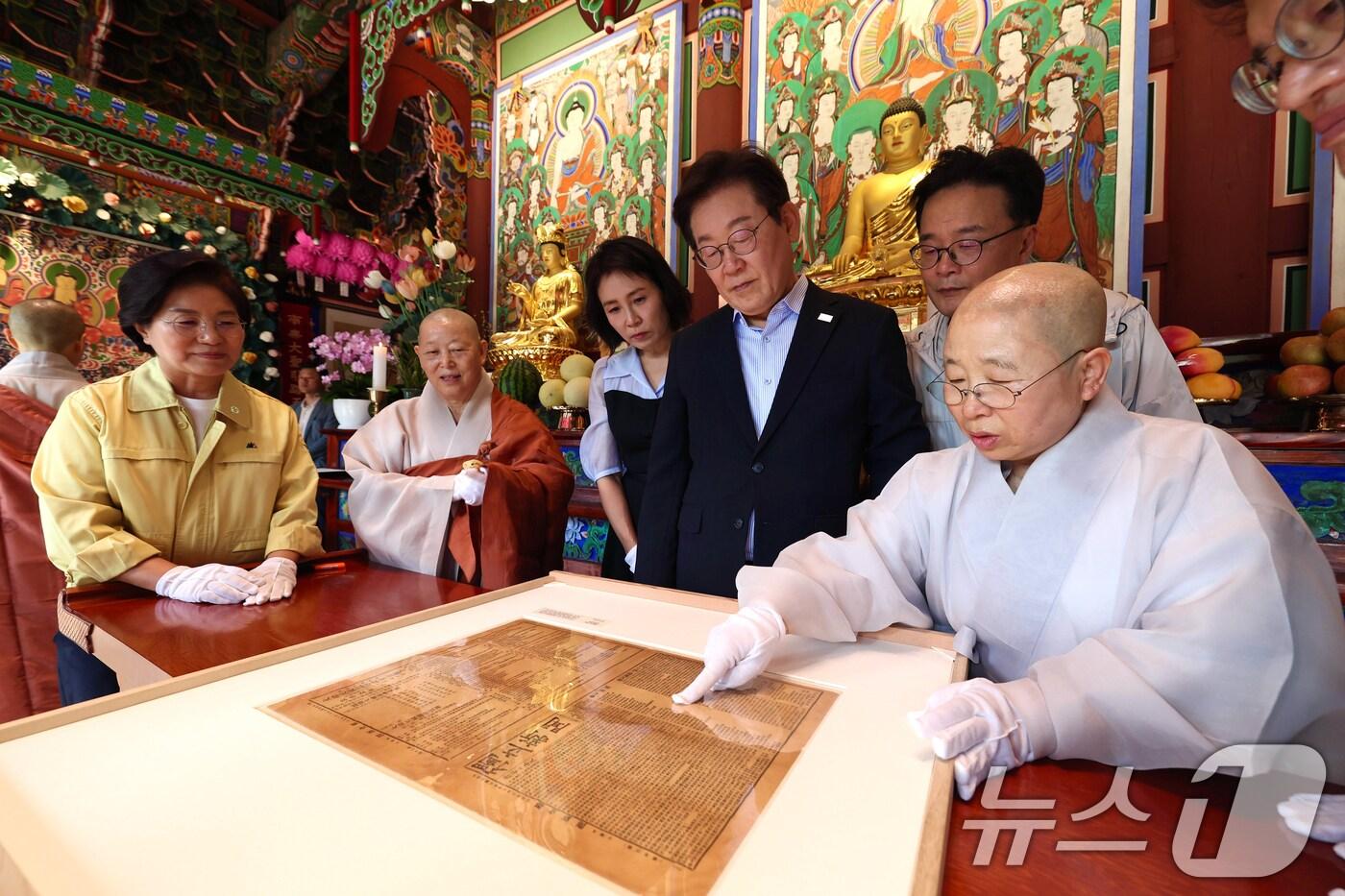 이재명 대통령과 김혜경 여사가 17일 서울 은평구 진관사를 방문해 2009년 진관사 복원과정에서 발견된 진관사 태극기와 독립신문을 보고 있다. (대통령실 제공. 재판매 및 DB 금지) 2025.8.17/뉴스1 ⓒ News1 허경 기자