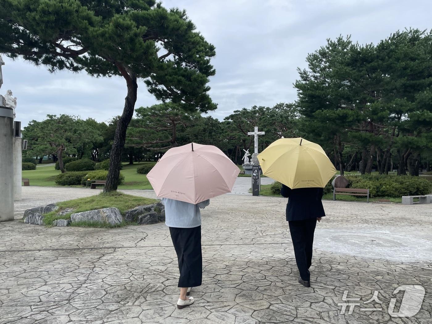 본문 이미지 - 당진 솔뫼성지에서 관광객들이 양우산 이용 모습(당진시 제공. 재판매 및 DB금지)2025.8.18/뉴스1