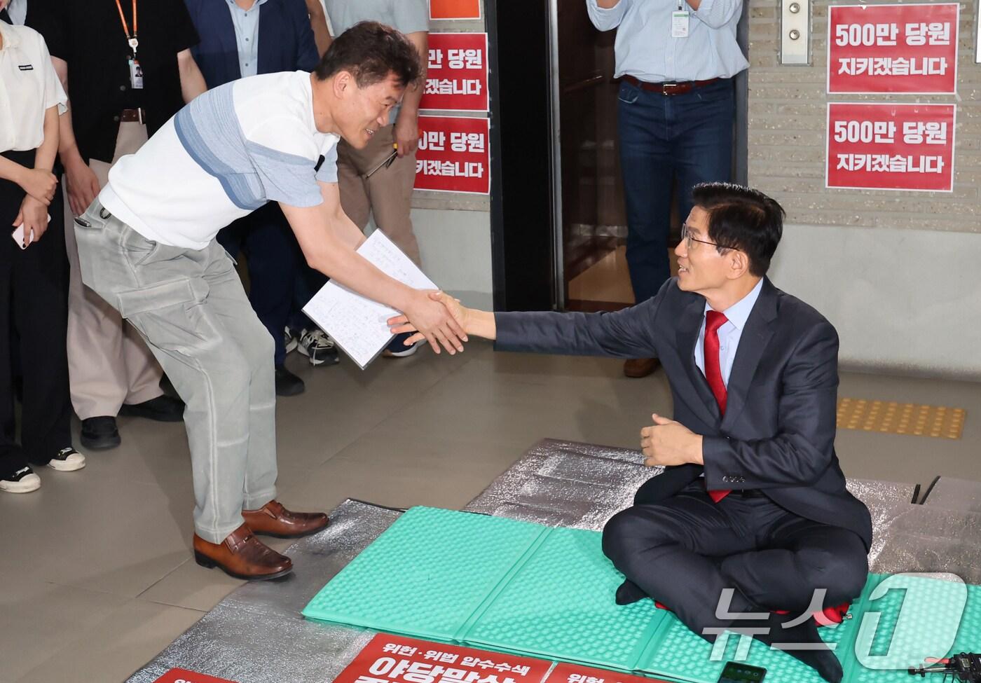 전한길 씨가 18일 오후 서울 여의도 국민의힘 중앙당사를 찾아 특검의 국민의힘 압수수색 저지 농성 중인 김문수 당대표 후보와 만나 악수하고 있다. 전 씨는 이 자리에서 장동혁 후보 지지와 관련된 보도에 대해 오해라는 입장을 밝혔다. 2025.8.18/뉴스1 ⓒ News1 장수영 기자