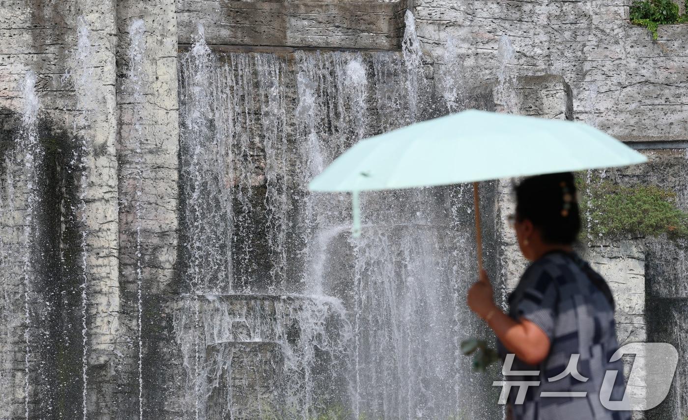 전국 대부분 지역에 폭염 경보나 주의보가 이어지고 있는 가운데 18일 오후 경기 오산시 수청공원에서 시민들이 시원하게 쏟아지는 폭포 앞으로 지나가고 있다. 2025.8.18/뉴스1 ⓒ News1 김영운 기자