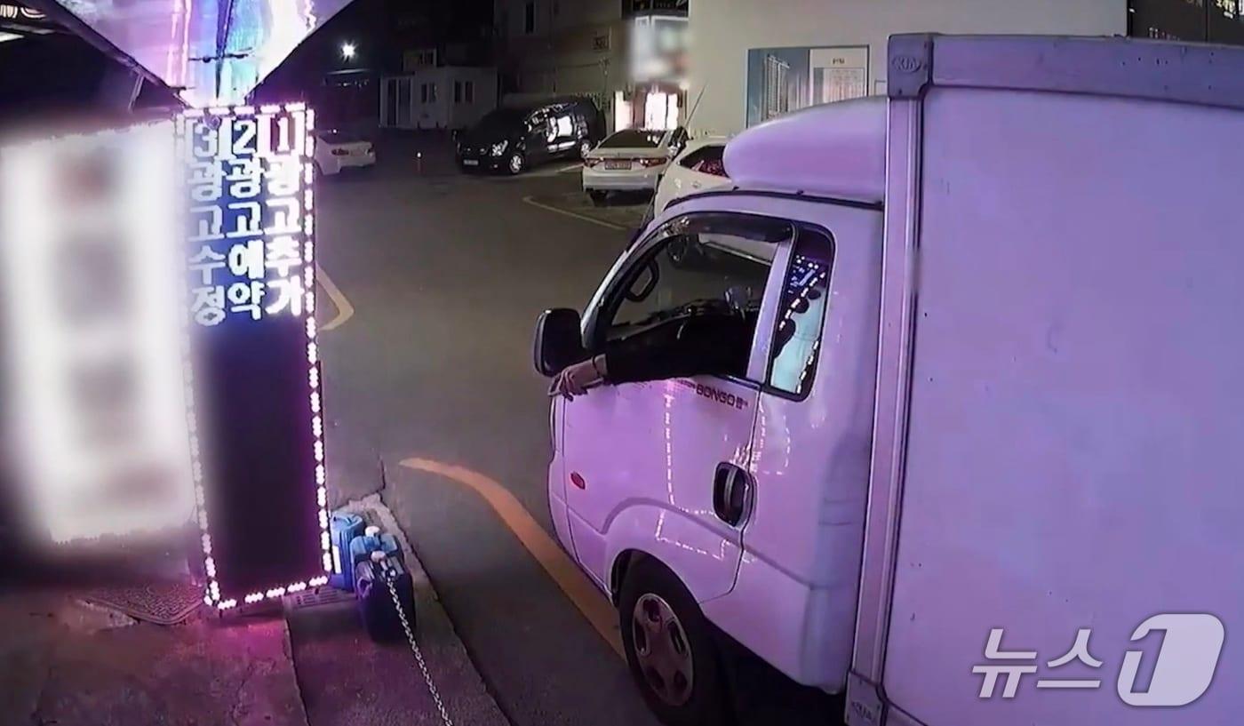 18일 검찰에 송치된 30대 남성이 리모컨을 이용해 LED 간판을 오작동난 것처럼 보이게 조종하고 있다.(부산 사하경찰서 제공. 재판매 및 DB 금지)