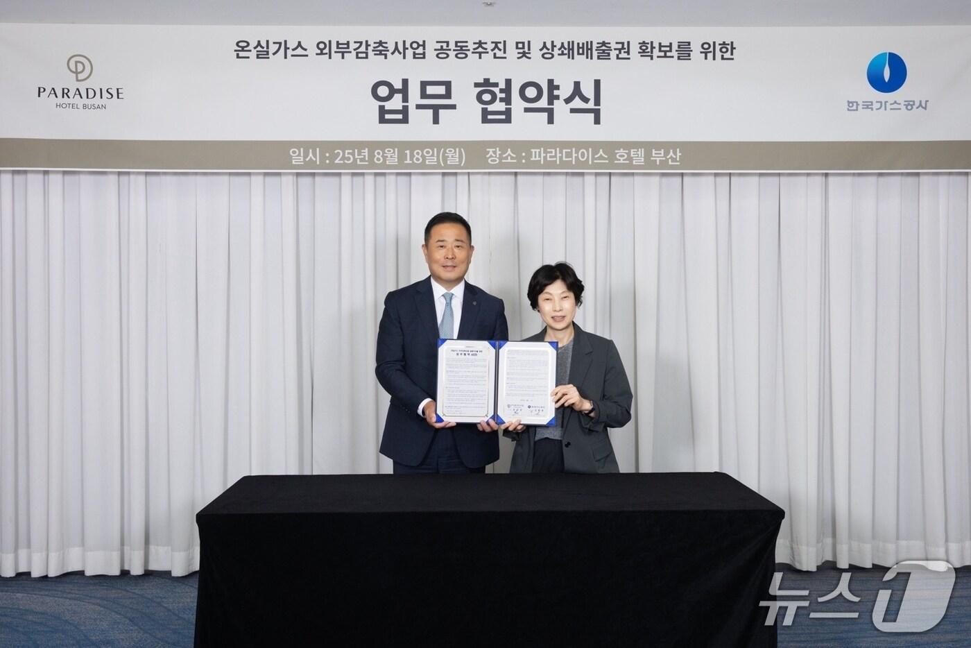 18일 부산 해운대구 파라다이스호텔에서 열린 '온실가스 외부감축사업 공동 추진 및 상쇄배출권 확보를 위한 업무협약식'에서 김경희 가스공사 기술기획실장(사진 오른쪽)과 윤진상 파라다이스호텔 총지배인이 기념촬영을 하고 있다(한국가스공사 제공). 2025.8.19/뉴스1