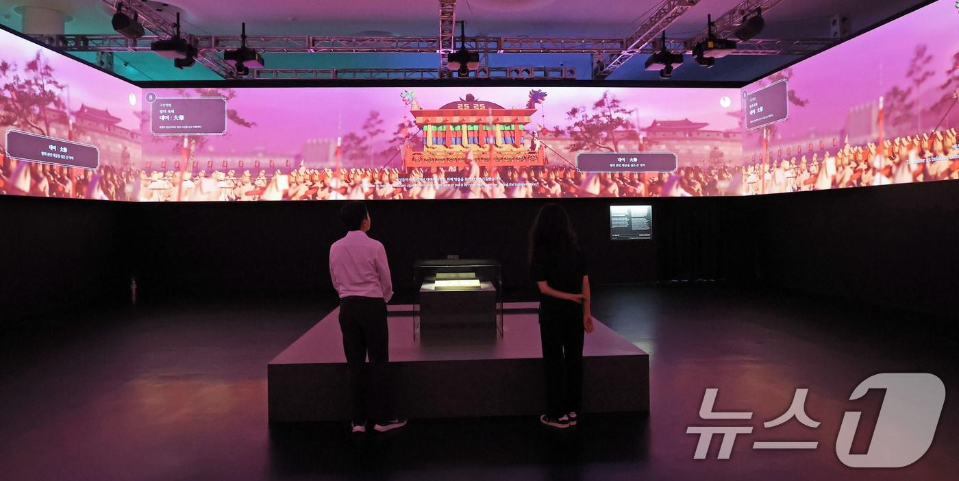 19일 서울 동대문구 동대문디자인플라자(DDP)에서 열린 국가유산 활용 디지털 콘텐츠 전시 '헤리티지: 더 퓨처 판타지' 언론 공개회에서 방문객들이 조선왕조 의괘에 기록된 왕실 의례를 3D 미디어아트로 제작한 '의괘, 영원의 서사'를 관람하고 있다. 국가유산청이 주최하고 국가유산진흥원이 주관한 '헤리티지: 더 퓨처 판타지'는 국내 최초로 다양한 국가유산 디지털 콘텐츠를 한자리에 모은 몰입형 체험 전시로 오는 23일부터 9월 17일까지 DDP 뮤지엄 전시2관에서 개최된다. 2025.8.19/뉴스1 ⓒ News1 오대일 기자