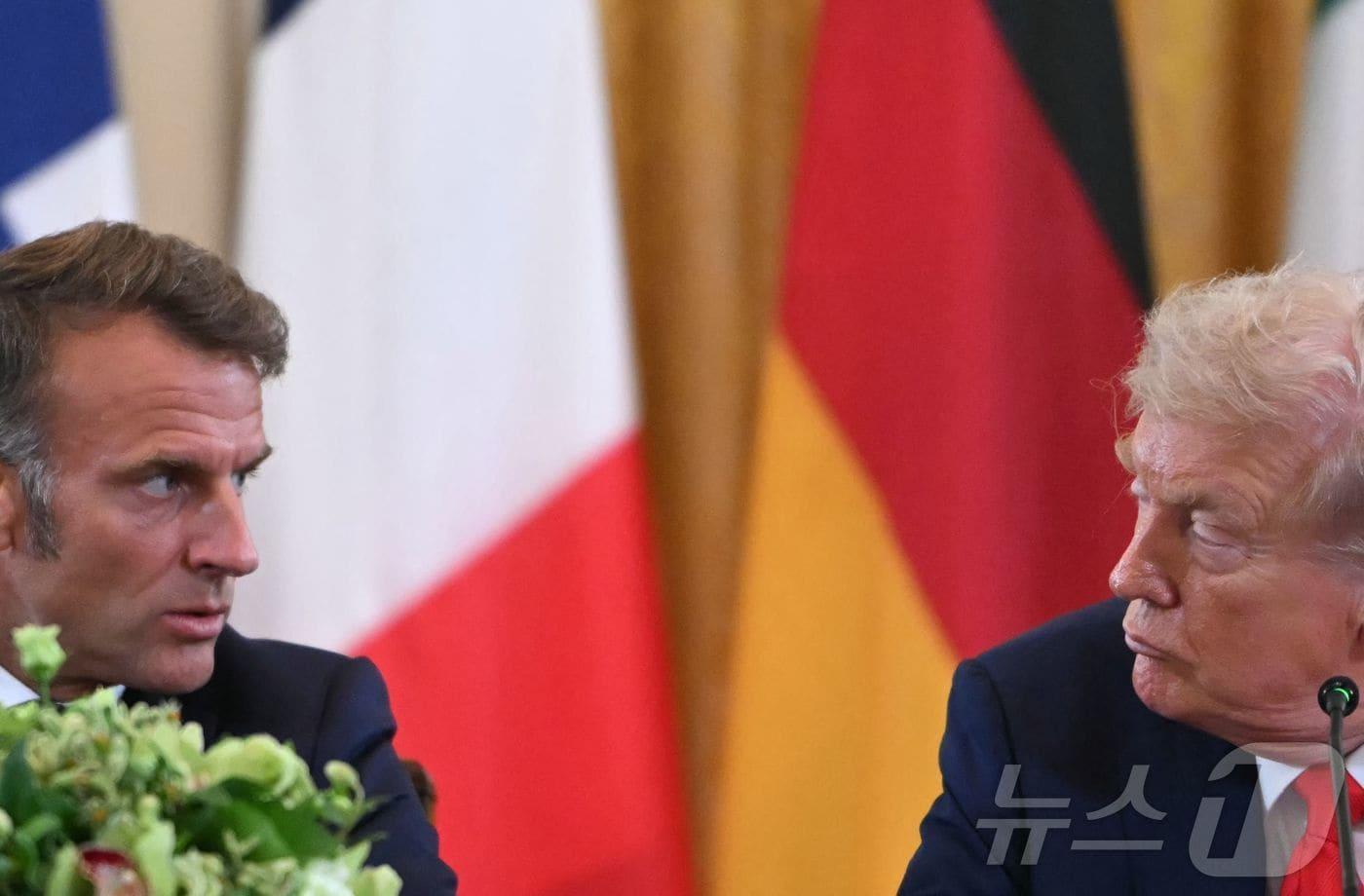 18일(현지시간) 백악관 이스트룸에서 도널드 트럼프 미국 대통령(오른쪽)이 에마뉘엘 마크롱 프랑스 대통령에게 무엇인가를 말하고 있다. 2025.08.18.ⓒ AFP=뉴스1