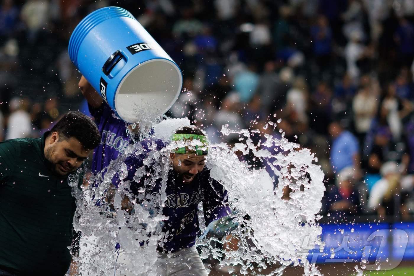 콜로라도 로키스의 워밍 베르나벨이 19일(한국시간) 열린 2025 메이저리그 LA 다저스전에서 9회말 끝내기 안타를 친 뒤 동료들의 물세례를 받고 있다. ⓒ AFP=뉴스1