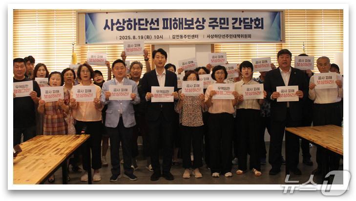 본문 이미지 - ‘사상~하단선 건설사업 15번째 땅꺼짐&#40;씽크홀&#41; 사고’ 주민 간담회에 참석한 전원석 시의원과 주민들이 공사 피해 보상을 촉구하는 손팻말을 들고 있다.&#40;부산시의회 제공. 재판매 및 DB금지&#41;