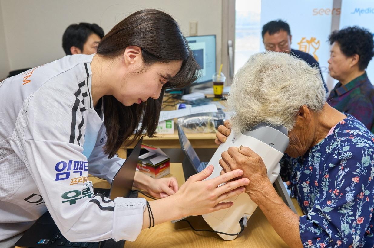 본문 이미지 - 대부도 주민이 AI 실명질환 진단 솔루션 &#39;위스키&#39;와 안저카메라 &#39;옵티나 제네시스&#39;를 활용해 안저 상태를 확인하고 있다.&#40;대웅제약 제공&#41;/뉴스1