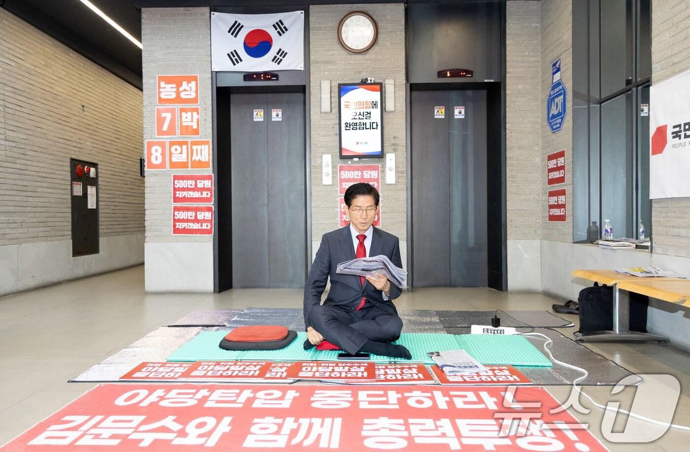 특검의 국민의힘 압수수색 저지 농성 중인 김문수 당대표 후보가 20일 서울 여의도 국민의힘 중앙당사 로비에서 신문을 읽고 있다. ⓒ News1 이승배 기자