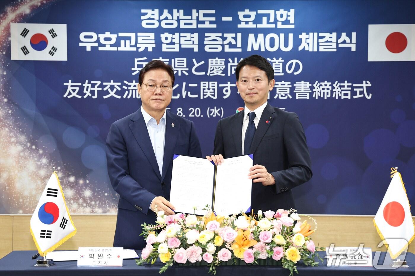 박완수 경남지사(왼쪽)가 20일 도청을 방문한 일본 효고현 사이토 모토히코 지사와 우호 교류 증인 합의서를 작성한 뒤 기념촬영을 하고 있다.(경남도 제공. 재판매 및 DB금지)