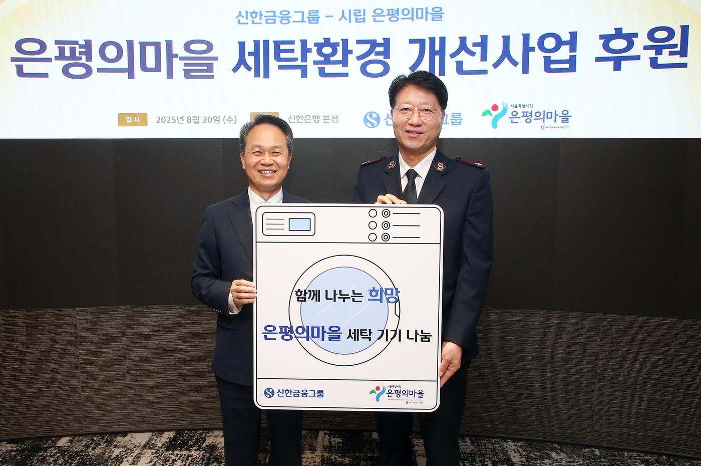 신한금융그룹은 20일 은평구 노숙인 요양시설 ‘은평의마을’에 대형 세탁기와 건조기를 기부하는 전달식을 진행했다. 이날 행사에 참석한 진옥동 신한금융그룹 회장(왼쪽)과 장경환 은평의마을 원장(신한금융 제공).