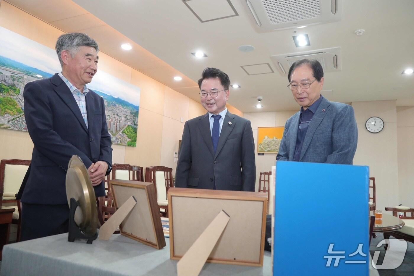 21일 강원 춘천시청 접견실에서 방선복씨&#40;사진 왼쪽부터&#41;, 육동한 시장, 정철수 씨가 캠프페이지 기증 물건을 둘러보고 있다.2025.8.21 한귀섭 기자