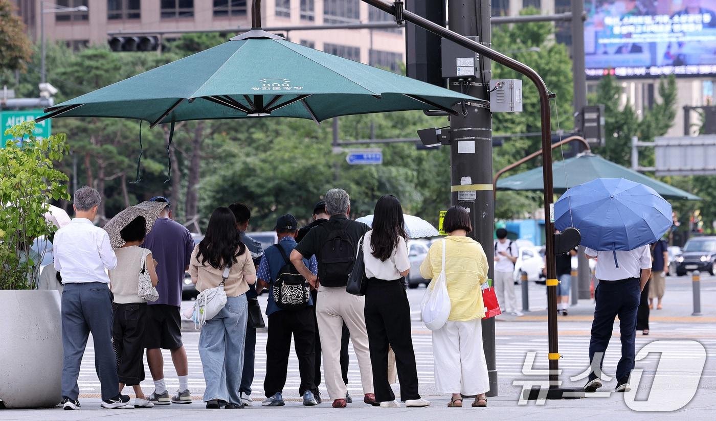 절기상 ‘처서’가 이틀 앞으로 다가왔지만 여전히 찜통 더위가 이어진 21일 오후 서울 광화문네거리에서 시민들이 횡단보도 앞 그늘막 아래 모여 신호를 기다리고 있다.  2025.8.21/뉴스1 ⓒ News1 박지혜 기자