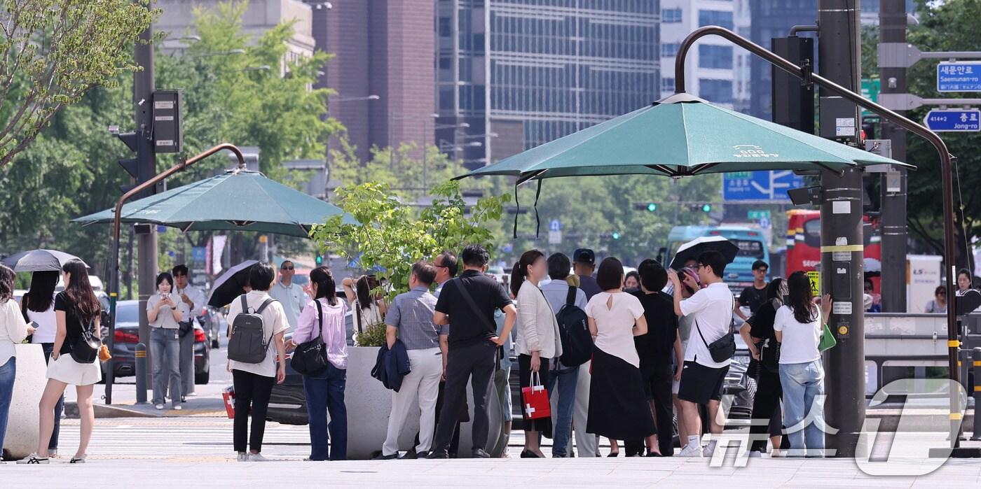 절기상 ‘처서’가 하루 앞으로 다가왔지만 여전히 찜통 더위가 이어진 21일 오후 서울 광화문네거리에서 시민들이 횡단보도 앞 그늘막 아래 모여 신호를 기다리고 있다.  2025.8.21/뉴스1 ⓒ News1 박지혜 기자