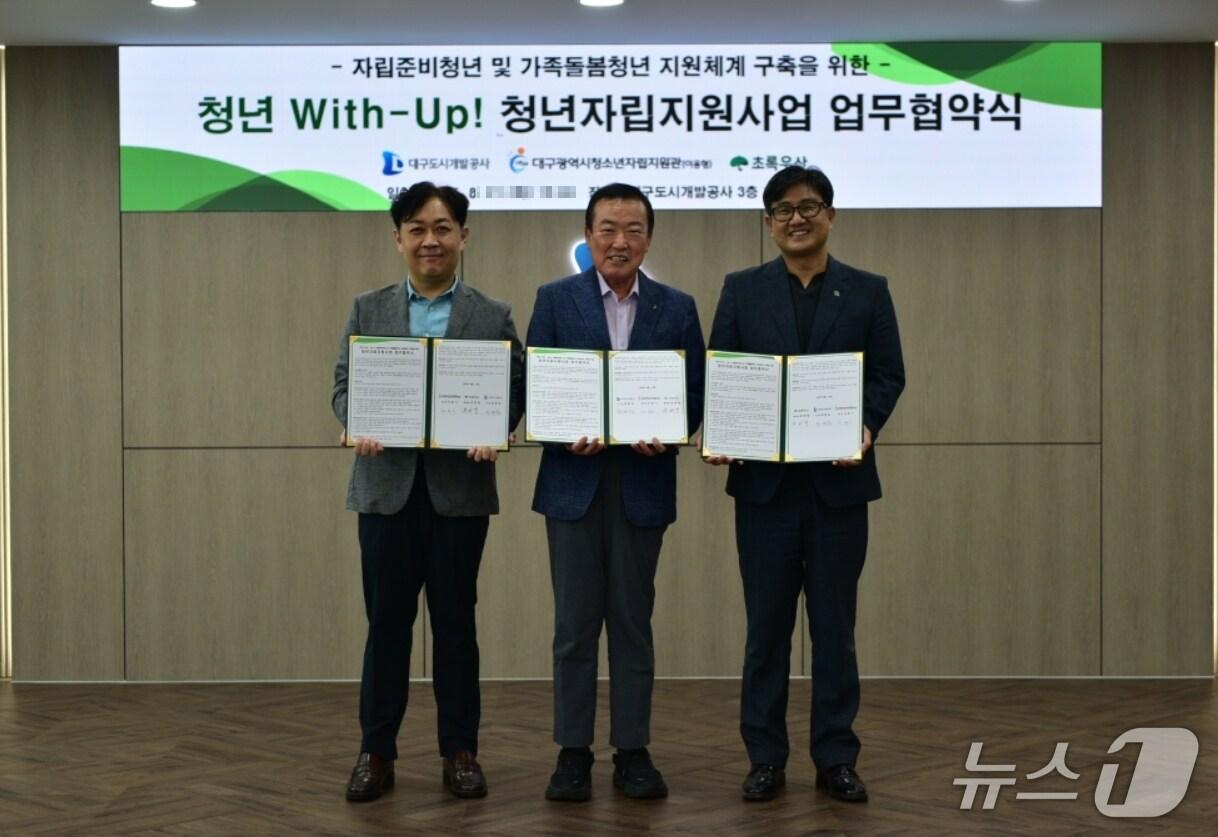 본문 이미지 - 정명섭 대구도시개발공사 사장(가운데)이 이준기 대구청소년자립지원관장(왼쪽), 문희영 초록우산어린이재단 대구지역본부장과 청년 위드업(With-Up) 자립지원사업 업무협약을 체결하고 협약서를 펼쳐 보이고 있다.(대구도시개발공사 제공. 재판매 및 DB 금지)