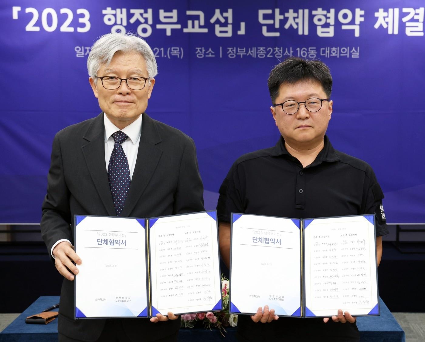 본문 이미지 - 최동석 인사혁신처장(왼쪽)이 지난 21일 세종시 정부세종청사에서 열린 '2023 행정부교섭' 단체협약 체결식에서 이철수 국가공무원노조위원장과 협약 체결 후 기념 촬영을 하고 있다.(인사처 제공)