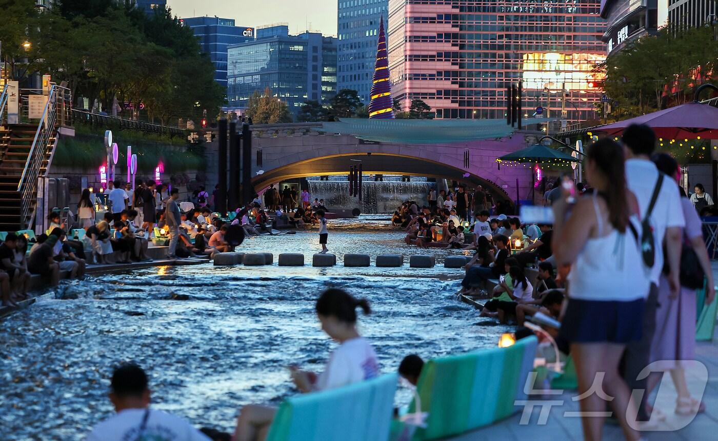열대야가 이어지고 있는 24일 저녁 서울 중구 청계천을 찾은 시민들이 더위를 식히고 있다. 2025.8.24/뉴스1 ⓒ News1 김진환 기자