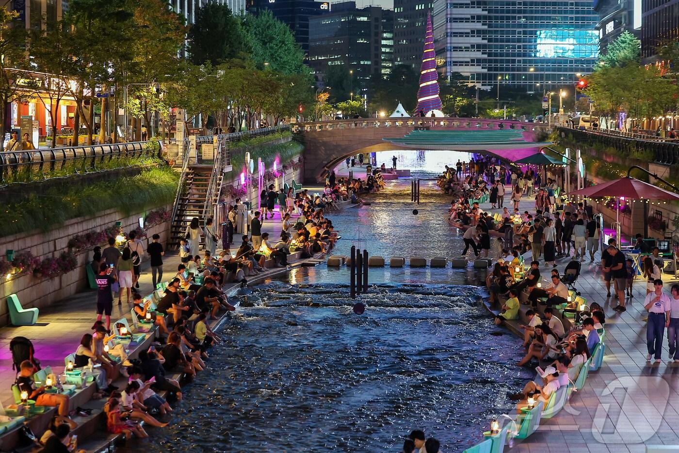 열대야가 이어지고 있는 24일 저녁 서울 중구 청계천을 찾은 시민들이 더위를 식히고 있다. 2025.8.24/뉴스1 ⓒ News1 김진환 기자