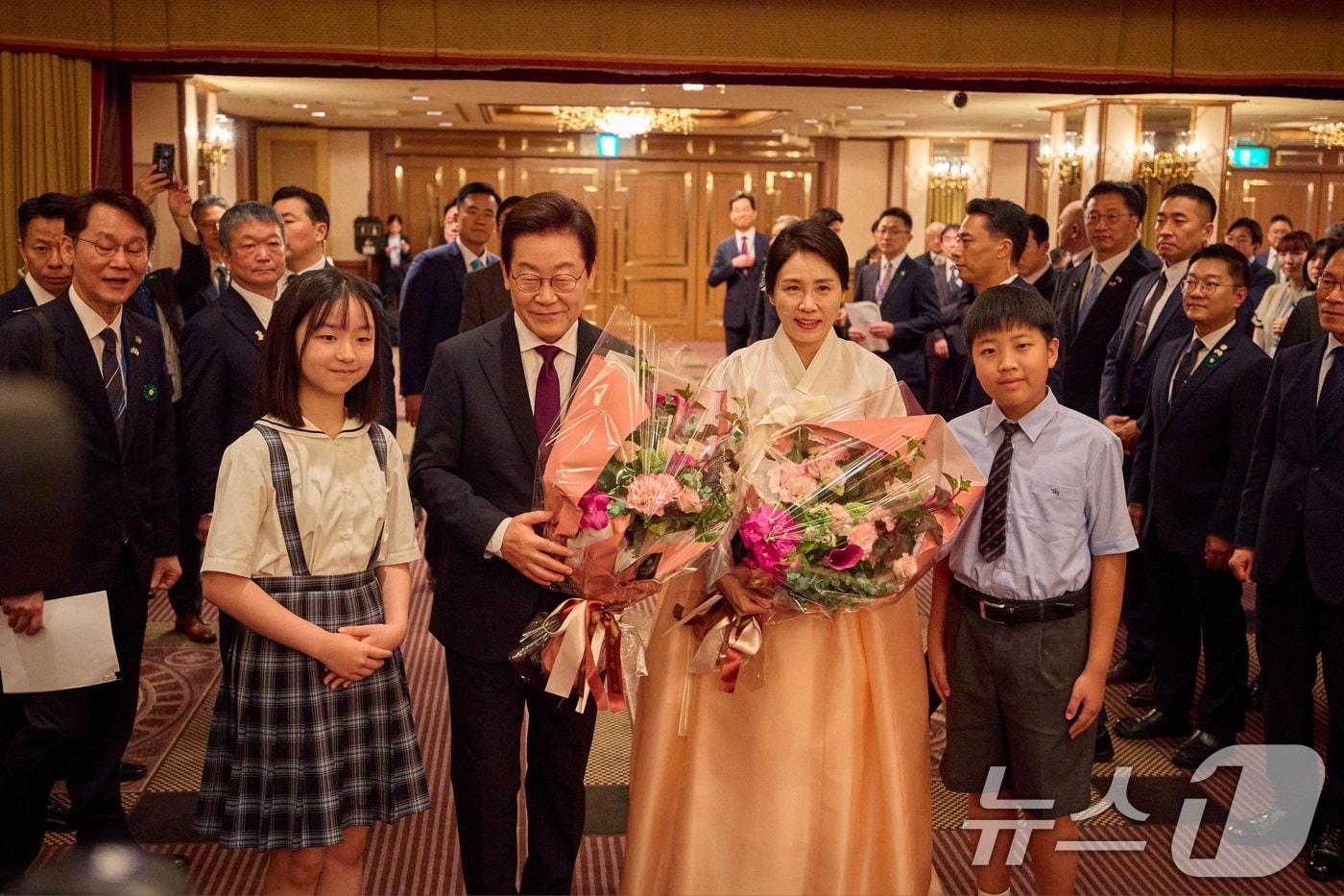 한일 정상회담을 위해 일본을 방문중인 이재명 대통령과 김혜경 여사가 23일&#40;현지시간&#41; 일본 도쿄의 한 호텔에서 열린 재일동포 오찬 간담회에서 화동들에게 꽃다발을 전달 받은 후 기념촬영을 하고 있다. &#40;이재명 대통령 SNS. 재판매 및 DB금지&#41; 2025.8.25/뉴스1 ⓒ News1 이재명 기자