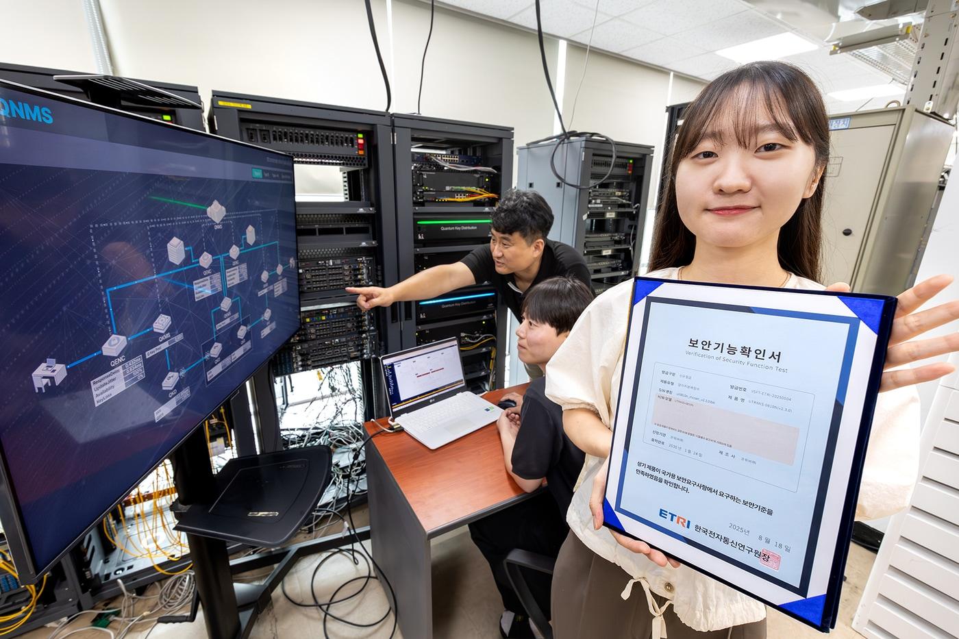 KT와 코위버 직원이 양자키분배 기술 적용 장비를 점검하며 보안 인증서를 소개하는 모습. &#40;KT 제공&#41;
