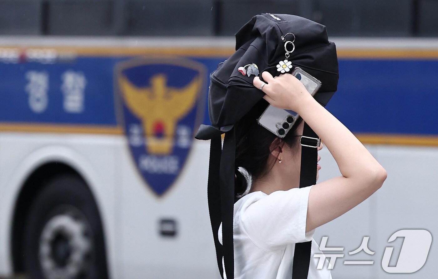 비가 내린 25일 오전 서울 종로구 광화문 일대에서 우산을 준비하지 못한 시민들이 가방으로 비를 막은 채 출근길 발걸음을 서두르고 있다. 2025.8.25/뉴스1 ⓒ News1 김성진 기자