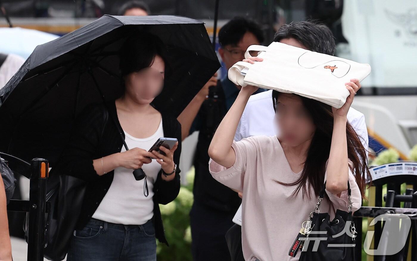 비가 내린 25일 오전 서울 종로구 광화문 일대에서 우산을 준비하지 못한 시민들이 가방으로 비를 막은 채 출근길 발걸음을 서두르고 있다. 2025.8.25/뉴스1 ⓒ News1 김성진 기자