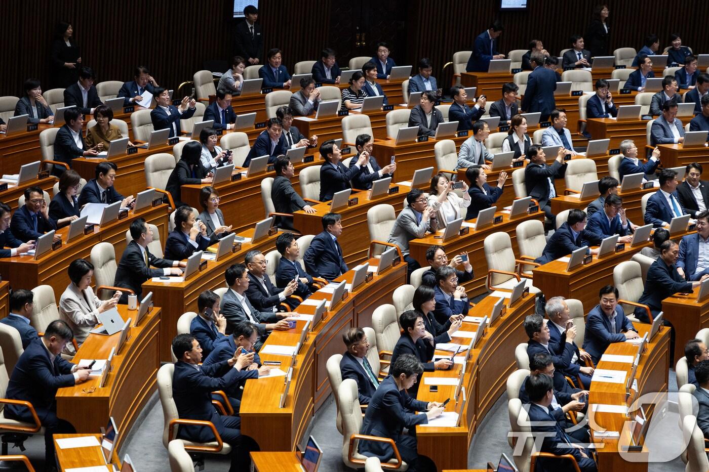 25일 서울 여의도 국회에서 열린 제428회 국회(임시회) 제2차 본회의에서 상법 일부개정법률안이 통과되자 여당 의원들이 표결 결과를 휴대전화로 촬영하고 있다. 2025.8.25/뉴스1 ⓒ News1 유승관 기자