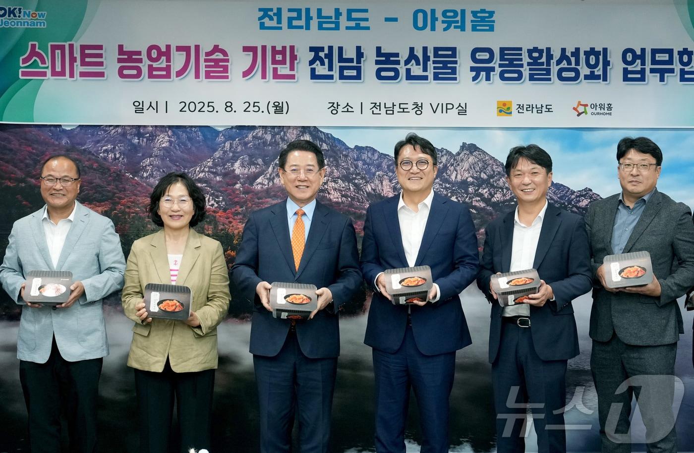 김영록 전남도지사가 25일 오후 도청 접견실에서 열린 한화 아워홈 김태원 대표이사와 '스마트 재배관리 솔루션'을 적용한 농산물의 안정적 생산과 유통활성화를 위한 업무협약식에서 아워홈에서 제작한 전남산 해남김치를 들어보이고 있다.(전남도 제공. 재판매 및 DB금지) 2025.8.25/뉴스1