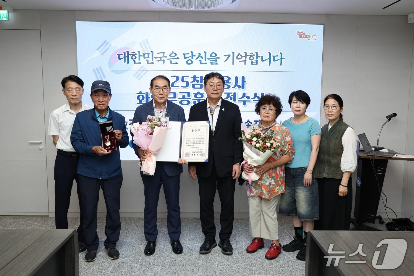 김해시가 25일 시청 정책회의실에서 6·25 전쟁 무공훈장 전수식을 열고 유족에 훈장을 전달하고 있다.(김해시 제공. 재판매 및 DB금지)