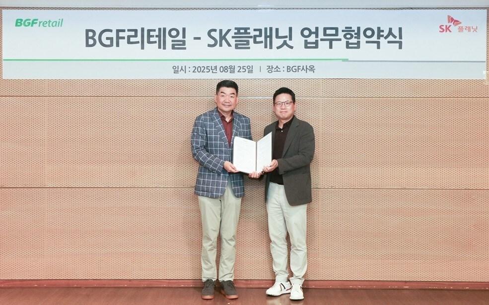 본문 이미지 - 오정후 BGF리테일 전략혁신부문장(좌측)과 김교수 SK플래닛 사업본부장(우측)이 MOU 기념 사진을 촬영하고 있다. (BGF리테일 제공)