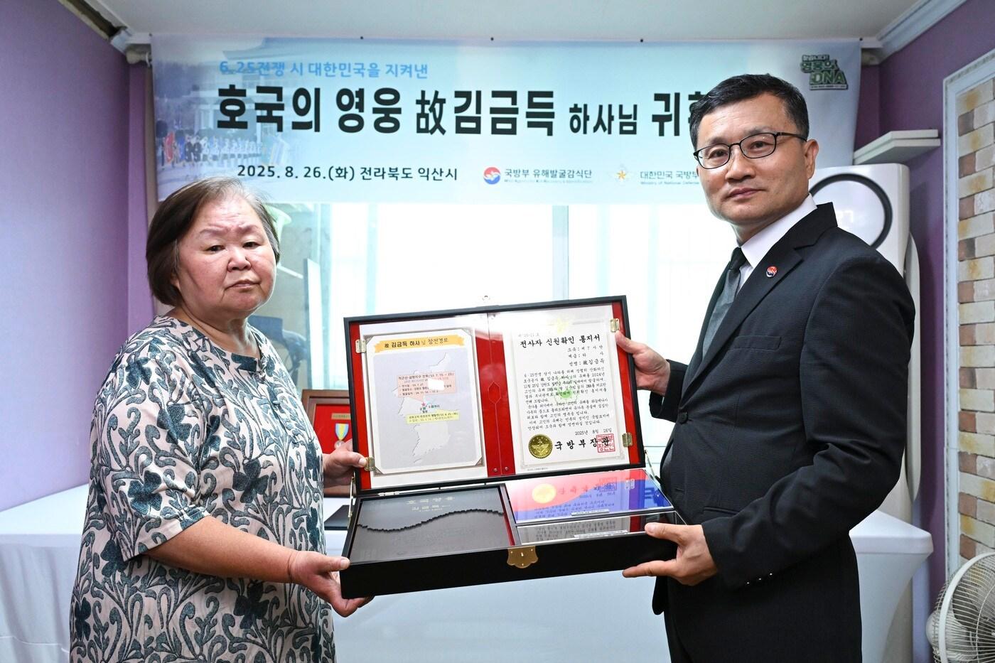 고&#40;故&#41; 김금득 하사의 유가족 대표인 김순임 씨&#40;71세&#41;가 이근원 국방부유해발굴감식단장으로부터 &#39;호국의 얼 함&#39;을 전달받은 후 기념사진을 촬영하고 있다.&#40;국방부 유해발굴감식단 제공&#41;