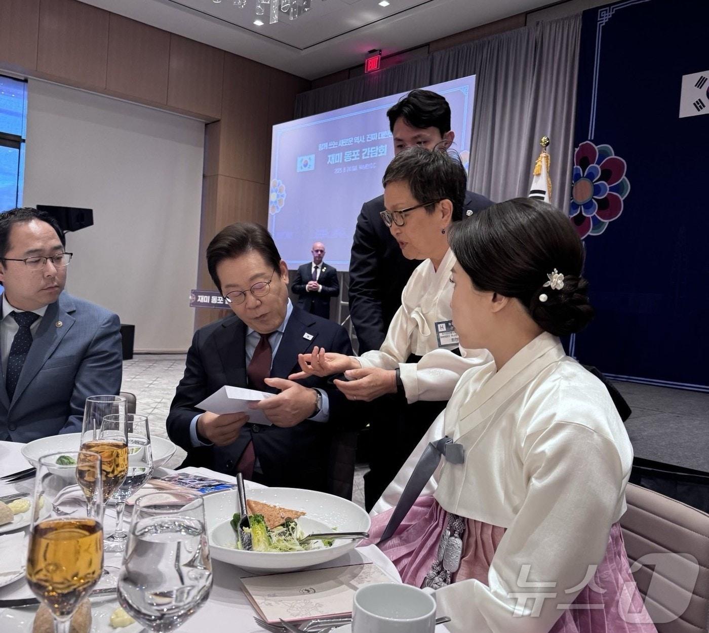 본문 이미지 - 이재명 대통령이 지난 24일&#40;현지시간&#41; 워싱턴DC에서 열린 동포간담회에서 한 달여 전 공항에서 체포된 한국인 이민자에 대한 도움을 요청하는 서한을 전달받아 읽고 있다. 2025.08.26. ⓒ News1 류정민 특파원