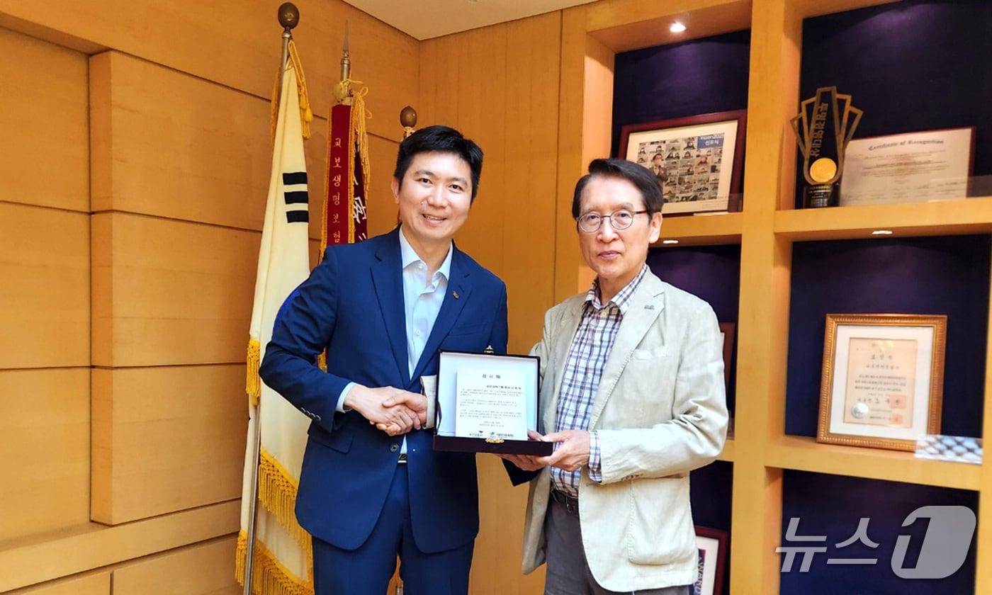 신창재 교보생명 대표이사 겸 이사회 의장(사진 오른쪽)과 유승민 대한체육회장이 지난 25일 서울 광화문 교보생명 본사에서 감사패 전달식을 마친 뒤 기념촬영을 하고 있다./사진제공=교보생명