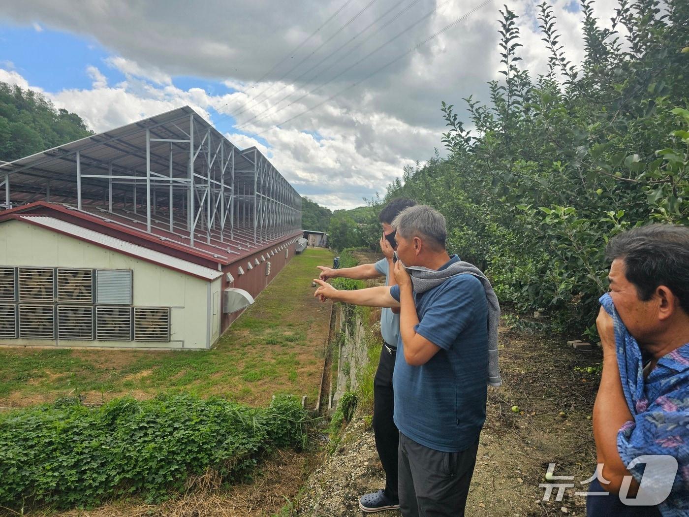 본문 이미지 - 27일 대형 환풍기가 쉴새 없이 돌아가고 있는 안동시 풍산읍 서미리 한 양계농장을 찾은 주민들이 악취를 견디지 못해 입과 코를 막고 있다. .2025.8.27/뉴스1 신성훈 기자