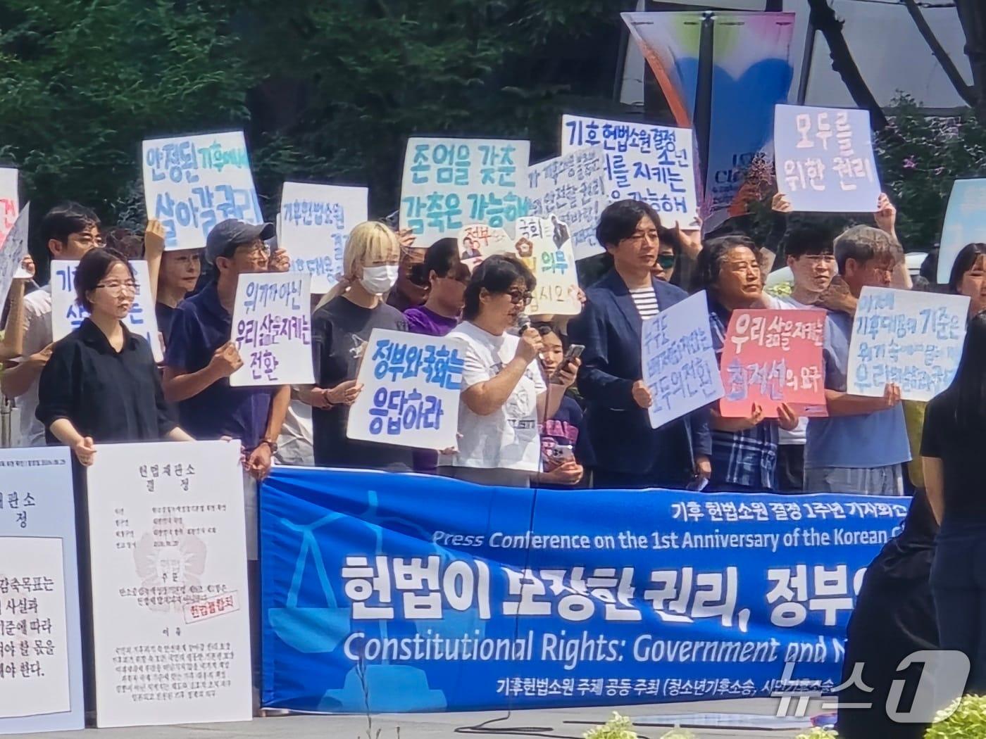 본문 이미지 - 기후 헌법소원&#40;청소년기후소송, 시민기후소송, 아기기후소송, 탄소중립기본계획위헌소송&#41; 소송 주체가 27일 광화문 광장에서 헌법소원 1주년 기자회견을 열고 있다. ⓒ 뉴스1 황덕현 기자