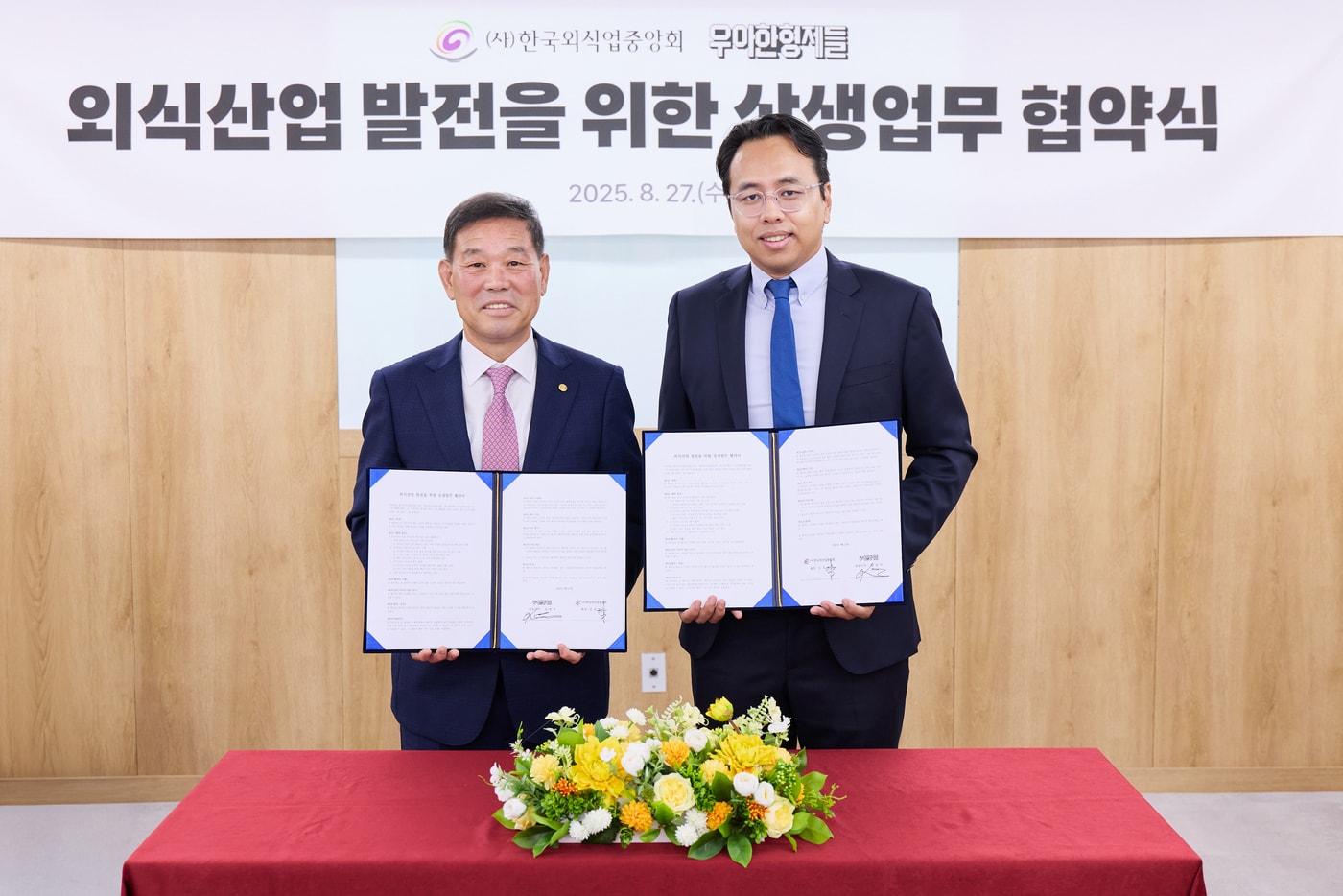 본문 이미지 - 27일 서울 중구에 위치한 한국외식업중앙회 본사에서 김범석 우아한형제들 대표이사(사진 오른쪽)와 김우석 한국외식업중앙회 회장이 '외식산업 발전을 위한 상생 업무협약'을 체결하고 있다. (우아한형제들 제공) 