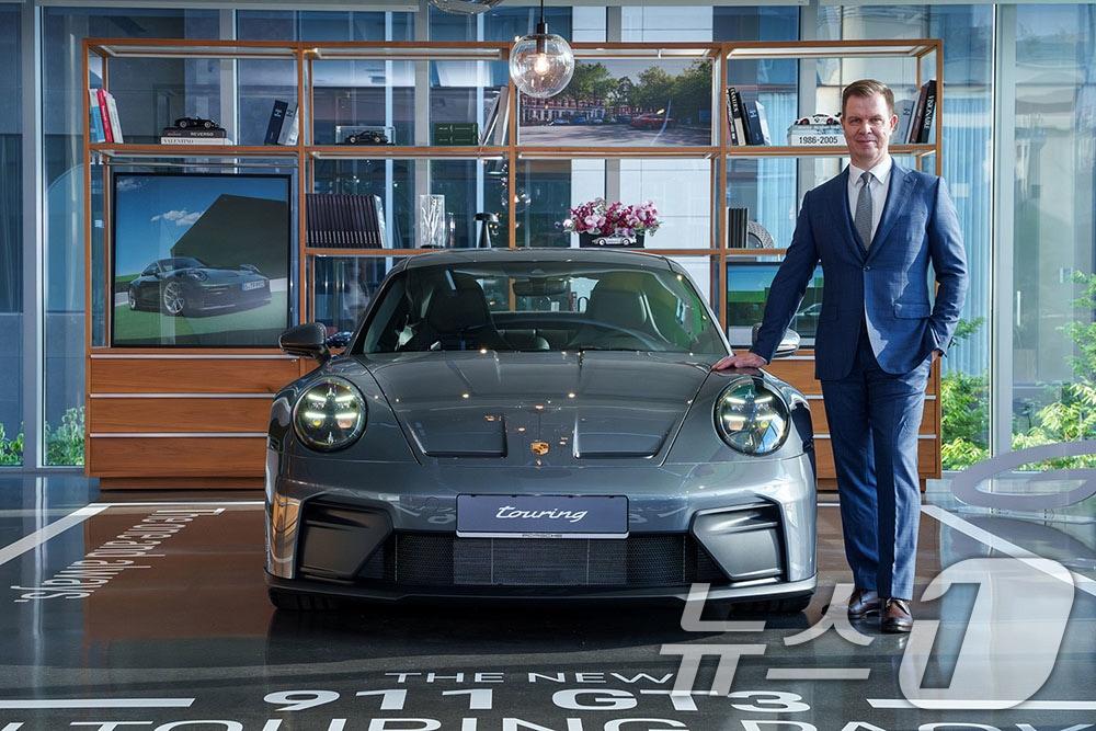 본문 이미지 - 마티아스 부세 포르쉐코리아 대표가 지난 8월 서울 강남구 포르쉐 스튜디오 청담에서 열린 '신형 911 스피릿 70 및 911 GT3 투어링 패키지' 프리뷰 행사에서 신형 911 GT3 투어링 패키지 앞에서 포즈를 취한 모습(자료사진. 포르쉐코리아 제공. 재판매 및 DB 금지) 2025.8.27/뉴스1