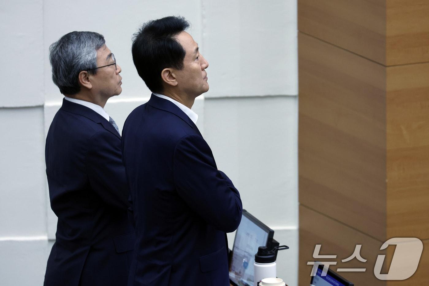 오세훈 서울시장과 정근식 서울시교육감이 27일 오후 서울 중구 세종대로 서울시의회 본회의장에서 열린 제332회 임시회 개회식에서 국민의례를 하고 있다. 2025.8.27/뉴스1 ⓒ News1 박정호 기자