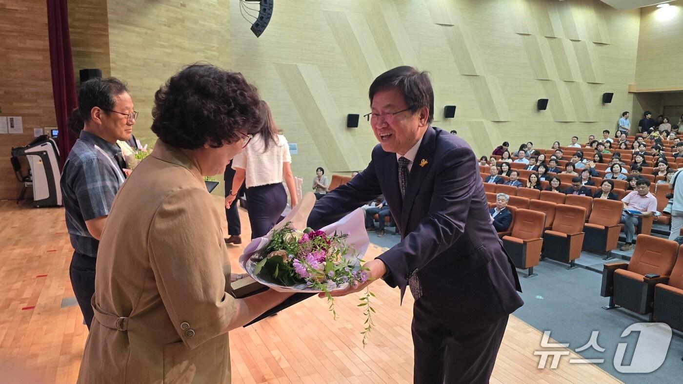 최교진 교육부장관 후보자(오른쪽)이 28일 오후 세종교육청 2층 대강당에서 열린 퇴직 교원 훈포장 전수식에 참석해 꽃다발을 전달하고 있다. / 뉴스1